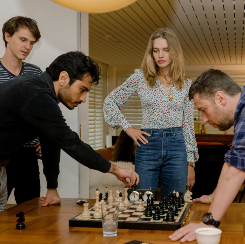 Arsha playing chess with friends around a table
