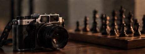 A camera beside a chess set